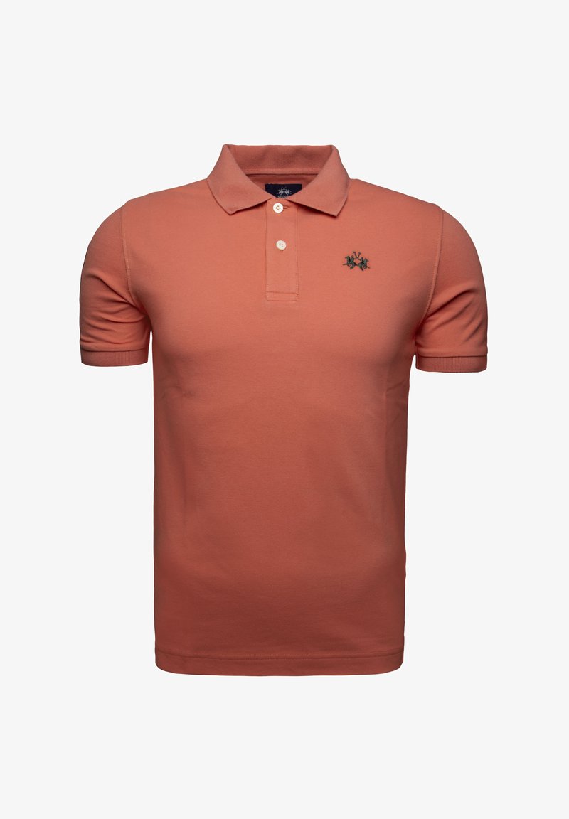 Polo de manga corta en color coral, hecho de algodón. Presenta un collar clásico, una tapeta con tres botones y un logotipo bordado en verde en el pecho.