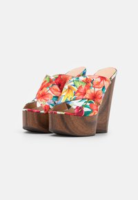 Open-toe bloempatroon wedgeschoenen zijn voorzien van een meerkleurige stof met hibiscusbloemen en tropische patronen, en hebben een houten structuur hak.