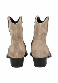 Bottines en daim beige clair avec une texture lisse, dotées d'un talon empilé bas et d'une fermeture éclair à l'arrière.