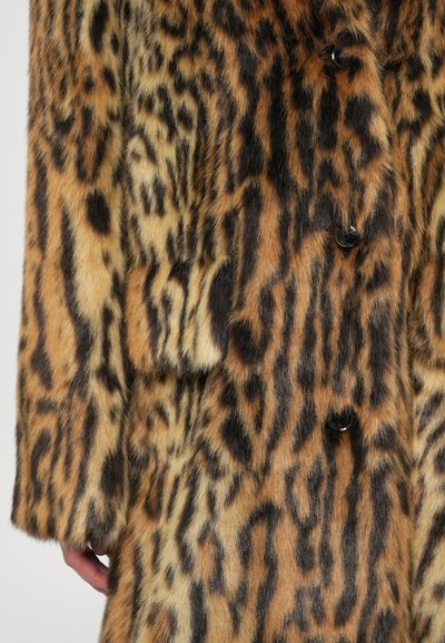 Casaco de estampa de leopardo em pelagem sintética suave. Apresenta uma base laranja-acastanhada com manchas pretas, quatro botões pretos e um único bolso decorativo.