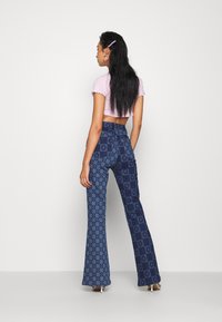 Jaded London FLOWER DISCHARGE PRINT WITH HEART BUTTON - Calças de ganga bootcut - blue