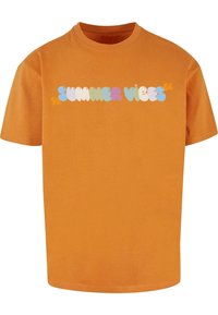 Orange bomulds T-shirt med rund hals og korte ærmer. Foran er der teksten "SUMMER VIBES" i farverig, boblende skrift.