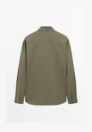 Chemise à manches longues vert olive, en tissu de coton. Comprend un col standard, un ourlet arrondi et des poignets à boutons avec deux boutons chacun.