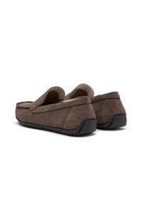 Pantofi slip-on din suede maro, cu talpă din cauciuc, având un design cusut și un profil jos. Interiorul pare că este căptușit pentru confort.