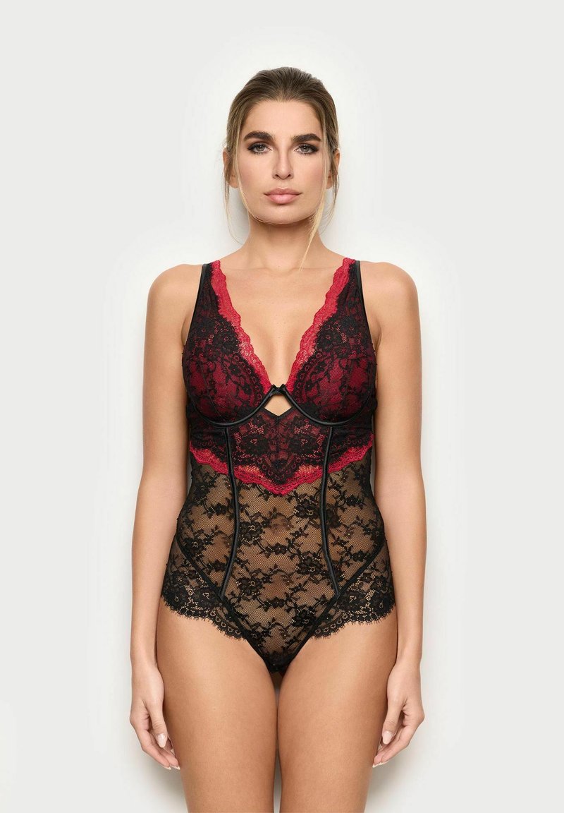 Czarny koronkowy body z czerwonymi falbaniastymi akcentami i przejrzystymi detalami, z głębokim dekoltem i skomplikowanymi kwiatowymi wzorami.