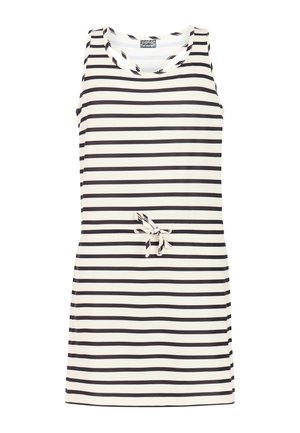 Niña con cabello largo y castaño que lleva un vestido sin mangas a rayas blancas y negras y chanclas negras, de pie con una mano en la cadera.