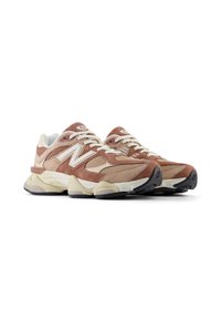 Zapatillas deportivas que combinan ante marrón y malla, con una suela acolchada y un prominente logotipo 'N' blanco en los laterales.