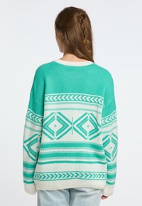 Turkos och off-white stickad tröja med geometriska mönster, med rund halsringning och lös passform, mjuk textur och ribbad fåll.