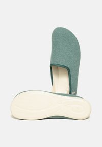 Green fabric slip-on shoe with a textured upper, soft lining, and a white rubber sole featuring a tread pattern for grip.