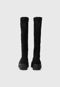 Schwarze Wildleder-Stiefel über das Knie mit glatter Textur, seitlichem Reißverschluss und einem stabilen Blockabsatz für zusätzliche Stabilität.