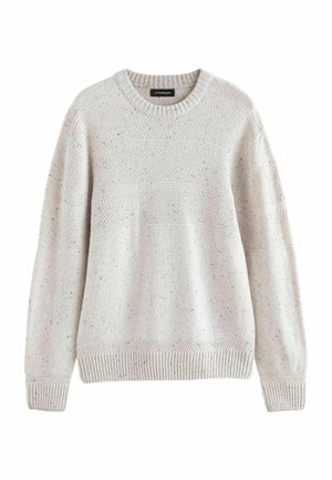 Vaaleanbeige neulepaita, jossa on pyöreä kaula-aukko. Pintakuvioita kauttaaltaan, hienovaraisella pilkullisella suunnittelulla. Ribbatut hihansuut ja helma.