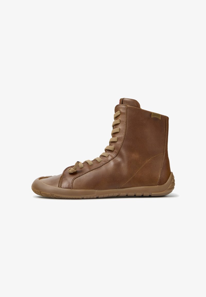 Baskets montantes en cuir marron avec lacets beige et semelle flexible en caoutchouc, vues de côté sur fond blanc.