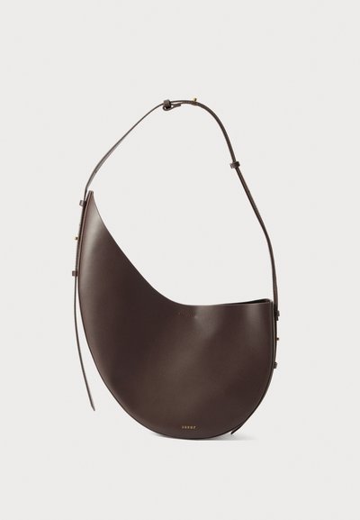 Sac à main en cuir brun avec une forme incurvée, une seule sangle et un design minimaliste. Présente un logo subtil et des accents en hardware doré.