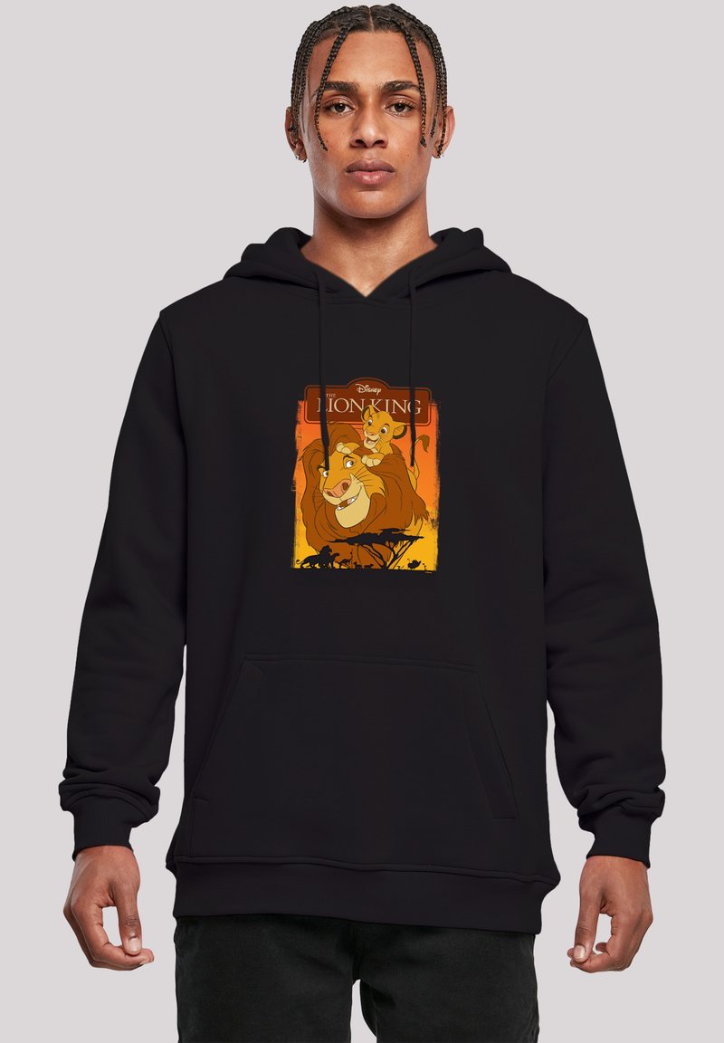 Melna hoody ar priekšējo kangaroo kabatu, kurā ir krāsains "Lauvu karalis" grafisks attēls, kurā redzams lauva un kucēns uz oranža fona.