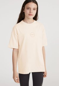 T-shirt en coton de couleur pêche, à manches courtes et coupe décontractée, avec un logo circulaire O'Neill dans un design subtil sur la poitrine.