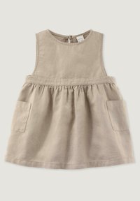 Beżowa lniana sukienka z okrągłym dekoltem, bez rękawów, z marszczoną talią i dwoma przednimi kieszeniami. Gładka faktura, proste detale szwów.