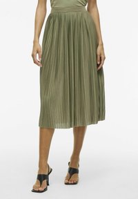 Gonna midi plissettata verde oliva con vita aderente, realizzata in un materiale liscio. Presenta pieghe verticali e un design fluido.