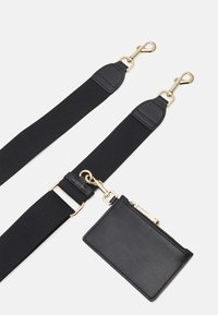 Cinghia in tessuto nero con moschettoni in oro. Include un portacarte in pelle nera abbinato con chiusura a zip. Design semplice e funzionale.