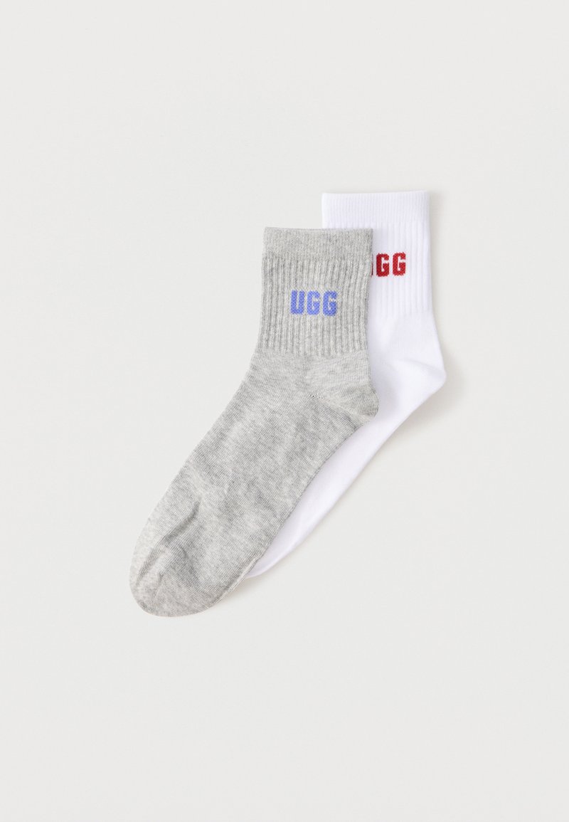 Κάλτσα γκρι με μοβ κείμενο «UGG» που επικαλύπτεται από μια λευκή κάλτσα με κόκκινο κείμενο «UGG», και οι δύο με ριμπ στο μανσέτι.