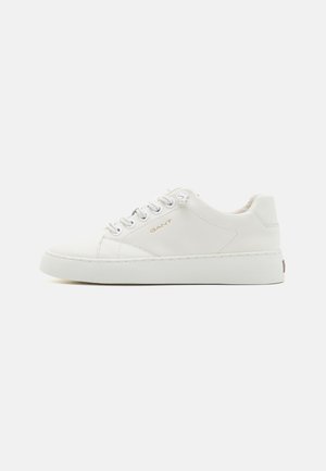 White leather sneakers with a smooth texture, round toe, and flat rubber sole. Features metallic eyelets and subtle logo detail on the side.