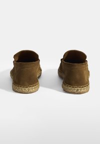 Bruine suède instap schoenen met een geweven jute zool en een ronde achterkant, met een gladde textuur en een eenvoudig ontwerp.