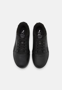 Baskets noires avec une tige en cuir lisse, une semelle en caoutchouc noire texturée et une doublure intérieure douce et pelucheuse. Dotées de lacets et d'un logo discret.