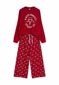 Czerwona sweatshirt z białym napisem graficznym i wzorem serca w paski jak cukrowa laskę; w połączeniu z czerwonymi spodniami z białymi wzorami serc. Dzianina z bawełny, luźny krój.
