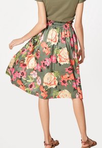 Bloemen midi-rok met een groene basis kleur. Heeft een geplooide elastische tailleband en grote rozen- en bloemenpatronen in roze, rood en geel.