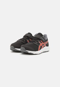Black athletic shoes with mesh upper, gray accents, red stripe, and Velcro strap. Treaded rubber sole for traction.