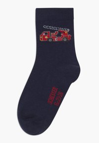 Chaussette bleu marine en tissu tricoté. Présente un design de camion de pompiers rouge sur le haut et un texte rouge sur la semelle indiquant la taille.