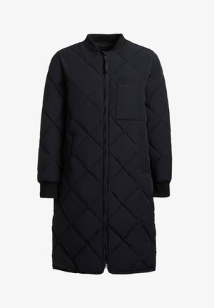 Long manteau noir matelassé avec fermeture éclair, poignets côtelés et poche poitrine sur le côté gauche.