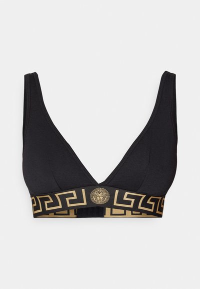 Fekete bralette, mély V-nyakkal, arany geometrikus pánttal és középen egy kör alakú Medúza logóval. Simább anyag, rugalmas támogatással.
