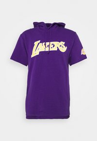 Felpa corta a maniche corte di colore viola con logo "Lakers" giallo e bianco sul petto e piccolo simbolo Lakers sulla manica sinistra.