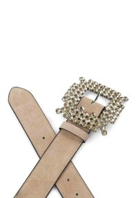 Beżowy pas z ekoskóry z dużą, ozdobną klamrą z przezroczystymi kamieniami, prostokątnym kształtem i gładką fakturą; regulowany z dziurkami.