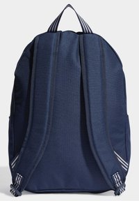 Marinblå ryggsäck gjord av slitstarkt tyg, med vadderade axelremmar, en vertikal design och randiga detaljer på remmarna.