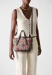 Borsa con motivo geometrico multicolore, realizzata in un tessuto testurizzato e con accenti in pelle marrone, dotata di manici doppi e una tracolla staccabile.