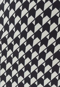 Čierno-biely materiál s geometrickým vzorom striedajúcich sa trojuholníkov, ktorý vytvára odvážny dizajn s hladkou textúrou.