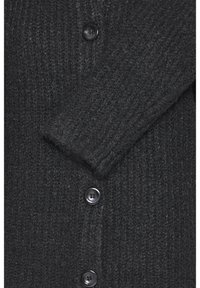 Tummanharmaa neulecardigan, jossa on ribbitekstuuri, viisi mustaa nappia, käännettävä kaulus ja hieman löysä istuvuus hihassa.