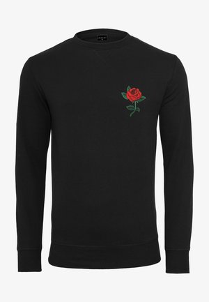 Musta collegepaita, jossa vasemmassa rinnassa punainen ruusu kirjailtuna, pyöreä kaula-aukko ja pitkät hihat, valmistettu pehmeästä kankaasta.