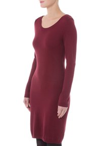 Abito a maniche lunghe di maglia bordeaux con scollatura a giro e polsini a costine, caratterizzato da una silhouette aderente e una texture morbida.