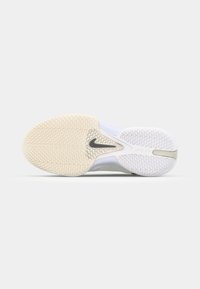 Hvid atletisk sko sål med et tekstureret design og et fremtrædende Nike-logo. Gummimaterialet har kontrastfarver i beige og hvid.