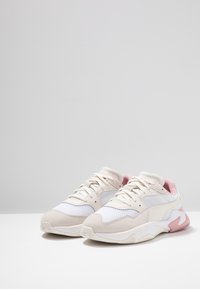 Lekki sneaker z siateczkową i zamszową chmurką w kolorze kremowym, białym i delikatnym różowym. Okrągły nosek, wyściółkowana podeszwa z falistymi akcentami. Klasyczny design na sznurówki.
