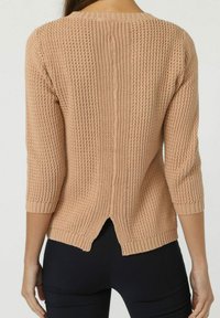 Jersey de punto en un beige claro con un patrón texturizado, mangas tres cuartos y una abertura en la espalda, con dobladillo y puños acanalados.