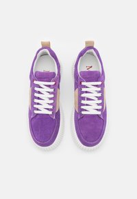 Baskets en suède violet avec des accents beiges, lacets blancs et semelle en caoutchouc texturée. Présente un col rembourré et une semelle intérieure avec logo embossé.