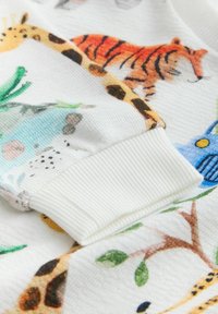 Trøje med blødt, tekstureret hvidt stof med farverige illustrationer af dyr og planter; ribstrikket manschet; legende designelementer.