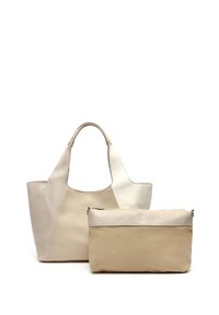 Beige och krämfärgad läderhandväska med vinklad design och två handtag, tillsammans med en mindre beige dragkedjeväska som har en slät yta.