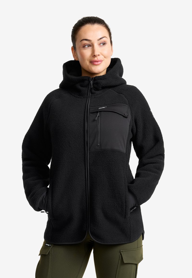 Svart fleecejacka med en ficka på bröstet med dragkedja, huva och en strukturerad yta. Har en smidig dragkedja och förstärkta sömmar.