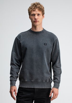 Dark gray sweatshirt featuring a ribbed crew neckline, long sleeves, and a small black logo patch on the chest. Soft, textured fabric.