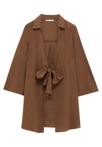 Chemise marron ample à manches longues avec col et nœud à l'avant, fabriquée en tissu léger texturé.