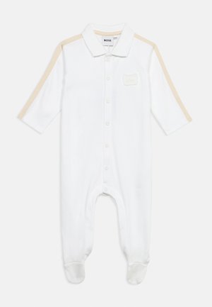 Body blanc pour bébé à manches longues, avec des rayures beiges sur les épaules, fermeture à boutons sur le devant, col, et étiquette BOSS sur la poche poitrine.